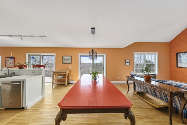 dining area with track lighting, plenty of natural light, and light wood-style flooring