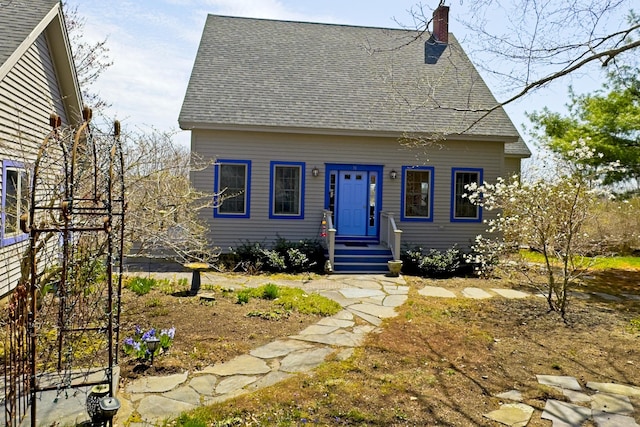 cape cod-style house with a shingled roof and a chimney