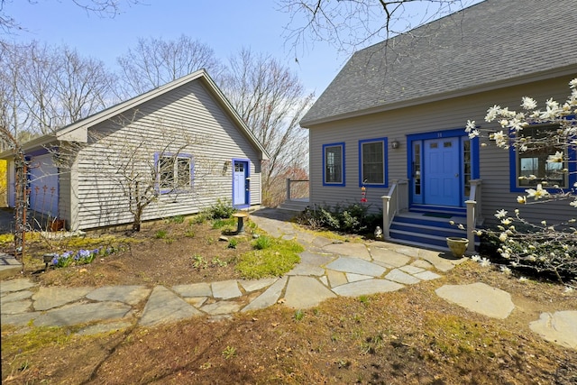 rear view of house with roof with shingles