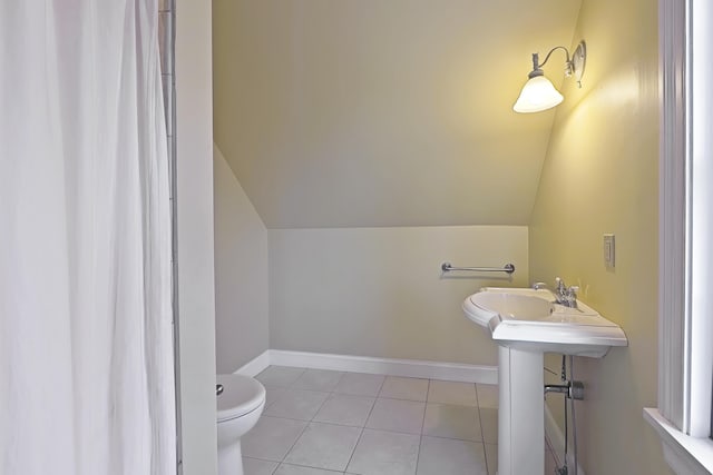 bathroom with toilet, tile patterned floors, and vaulted ceiling
