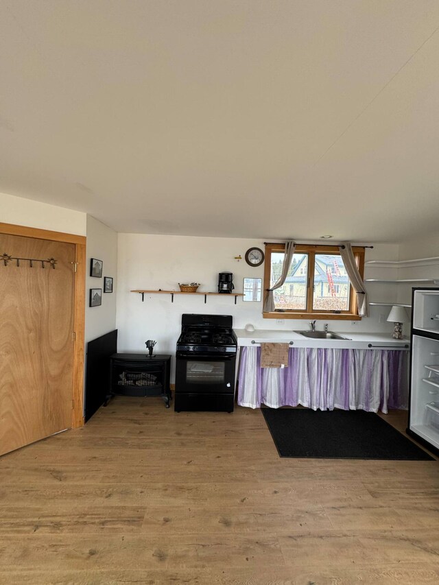 10 Wharf St, Jonesport, ME 04649 - kitchen with black range with gas cooktop, open shelves, a sink, and wood finished floors