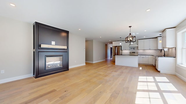 kitchen with dark countertops, appliances with stainless steel finishes, a sink, recessed lighting, and open floor plan
