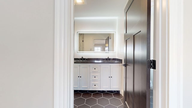 bathroom featuring double vanity, a sink, and tile patterned flooring