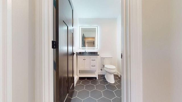 bathroom featuring toilet, tile patterned flooring, and vanity