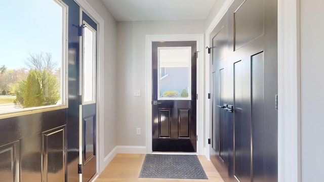 doorway featuring light wood-style floors and baseboards