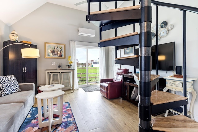living area featuring hardwood / wood-style flooring, a wall mounted air conditioner, and high vaulted ceiling