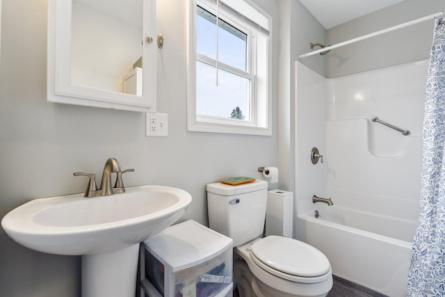 bathroom with toilet, shower / bath combo with shower curtain, and a sink