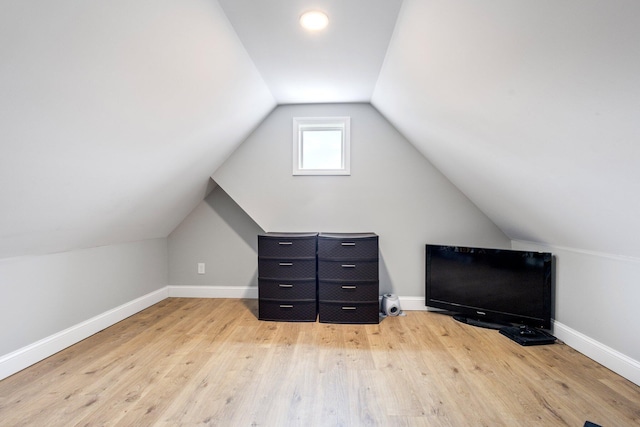 bonus room with light wood-style floors, vaulted ceiling, and baseboards