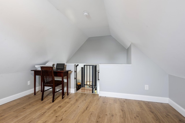office space with vaulted ceiling, baseboards, and wood finished floors