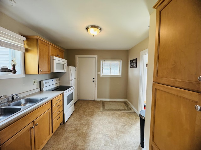 26 Hammond St, Caribou, ME 04736 - kitchen featuring brown cabinetry, white appliances, baseboards, light floors, and a sink