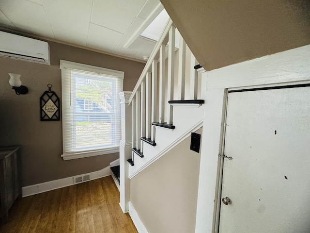 26 Hammond St, Caribou, ME 04736 - stairs with baseboards, an AC wall unit, wood finished floors, and visible vents