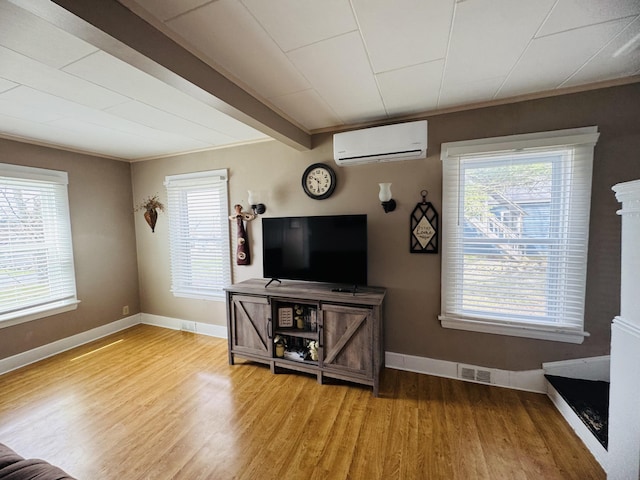 26 Hammond St, Caribou, ME 04736 - living room with a healthy amount of sunlight, light wood-style floors, an AC wall unit, and visible vents