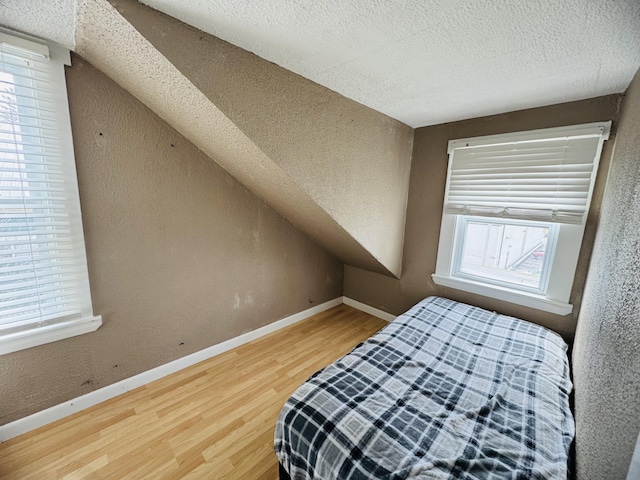 26 Hammond St, Caribou, ME 04736 - bedroom featuring a textured ceiling, a textured wall, baseboards, and wood finished floors