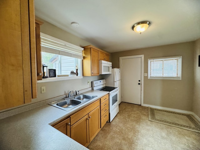 26 Hammond St, Caribou, ME 04736 - kitchen with a sink, brown cabinetry, white appliances, and a healthy amount of sunlight