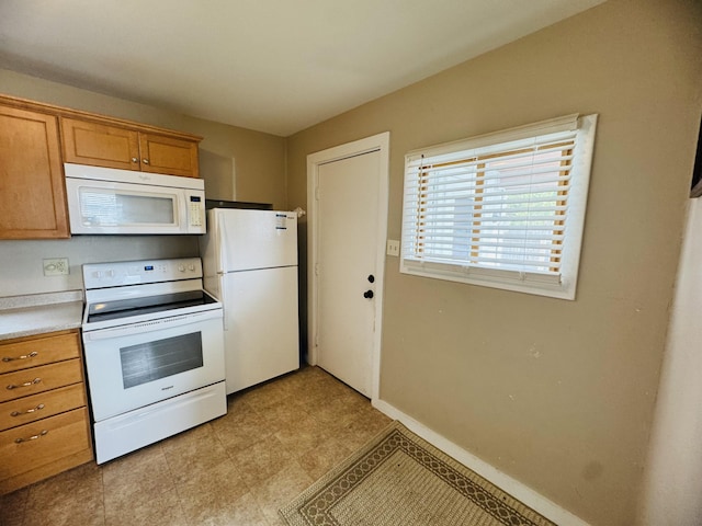 26 Hammond St, Caribou, ME 04736 - kitchen featuring light countertops, baseboards, brown cabinetry, and white appliances