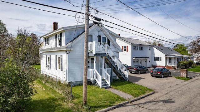 view of front of house featuring a chimney and fence