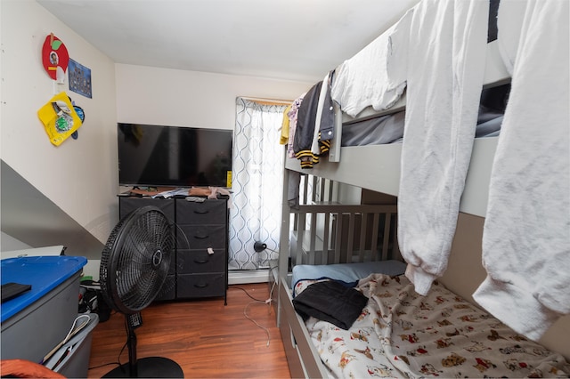 bedroom featuring wood finished floors and a baseboard radiator