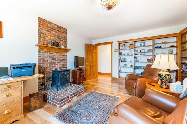 1515 Old Augusta Rd, Waldoboro, ME 04572 - living area with baseboards, a wood stove, and light wood finished floors