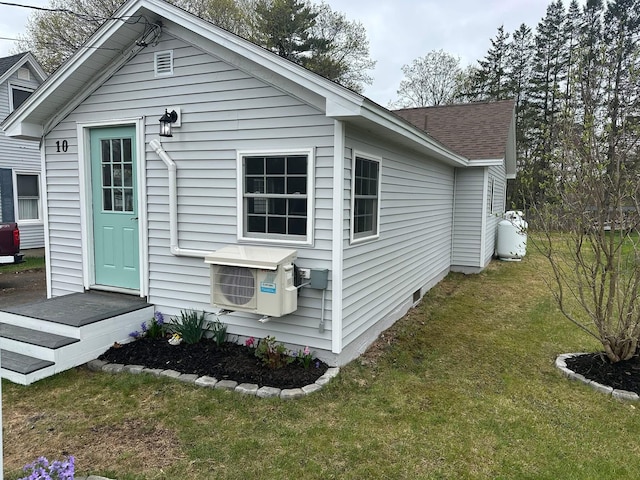 back of property featuring a lawn and ac unit