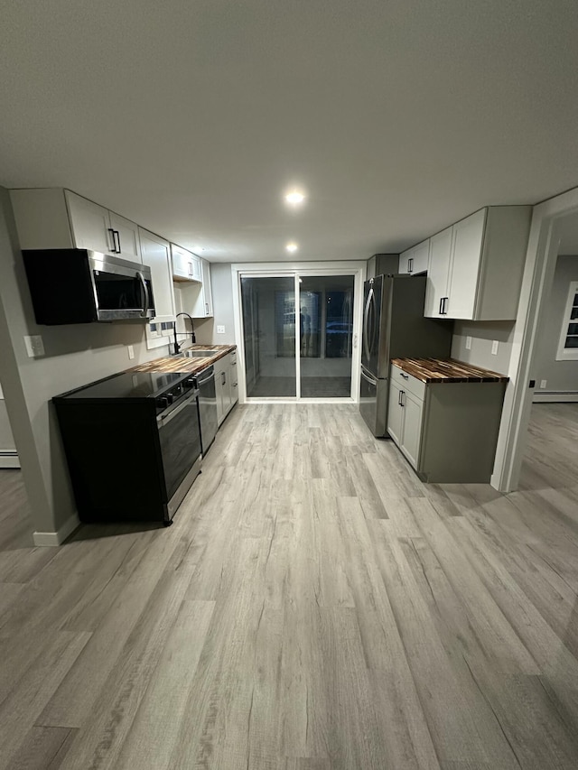 kitchen with a sink, stainless steel appliances, and light wood-style flooring