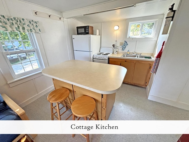 kitchen featuring white appliances, light floors, a center island, light countertops, and a sink