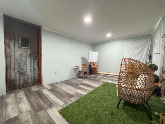 living area with ornamental molding and wood finished floors