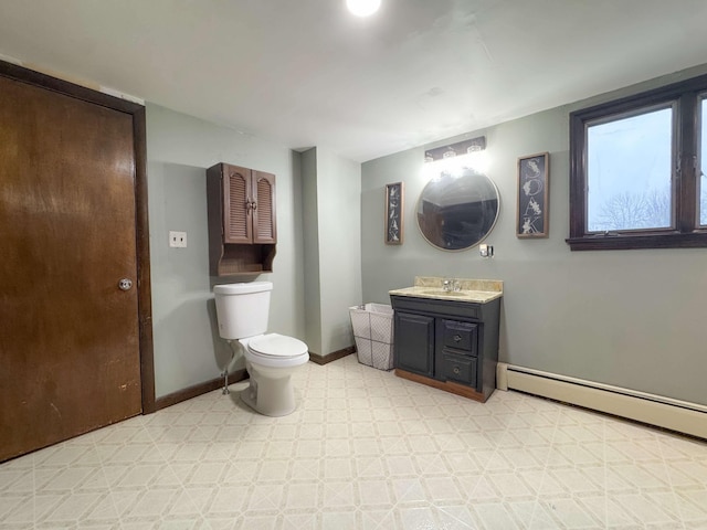 bathroom featuring baseboard heating, vanity, toilet, tile patterned floors, and baseboards