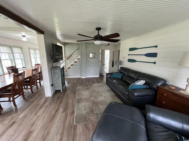 6 Gully Brook Ln, Orland, ME 04472 - living room featuring plenty of natural light, wood finished floors, a ceiling fan, stairs, and wooden walls