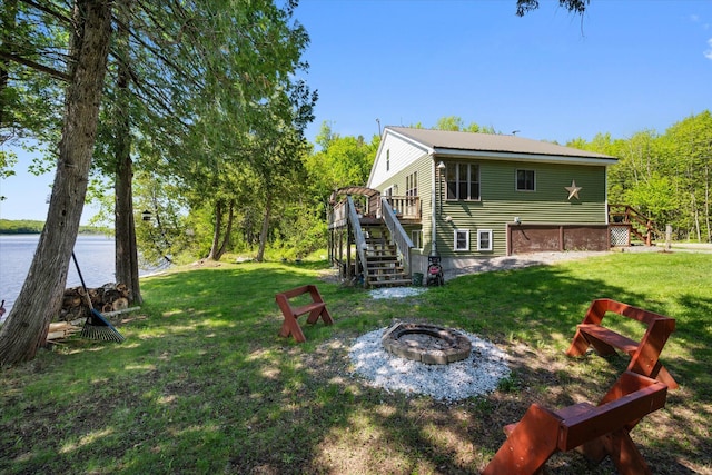 32 Whites Pond Rd, Palmyra, ME 04965 - rear view of property with stairs, a deck with water view, a fire pit, and a lawn