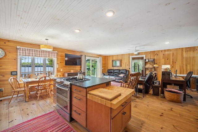 32 Whites Pond Rd, Palmyra, ME 04965 - kitchen featuring range with two ovens, wood walls, light wood-style floors, healthy amount of natural light, and wooden counters