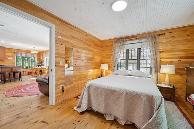 32 Whites Pond Rd, Palmyra, ME 04965 - bedroom with wooden walls and light wood-style flooring