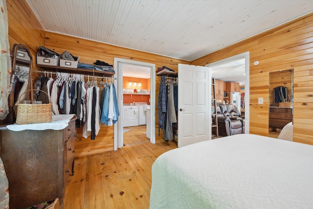 32 Whites Pond Rd, Palmyra, ME 04965 - bedroom featuring washer and clothes dryer, wood walls, and hardwood / wood-style flooring