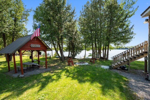 32 Whites Pond Rd, Palmyra, ME 04965 - view of grassy yard with a gazebo, a fire pit, stairway, and a water view