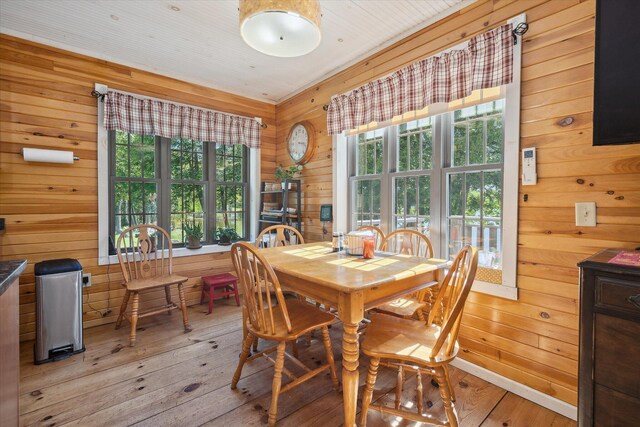 32 Whites Pond Rd, Palmyra, ME 04965 - dining room with wooden walls, light wood-type flooring, and healthy amount of natural light