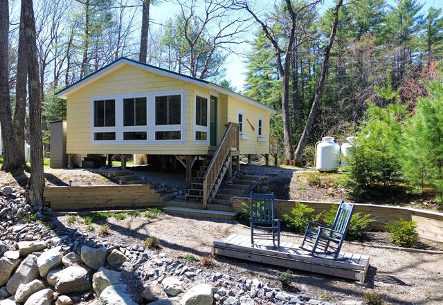 rear view of property featuring a wooden deck and stairway