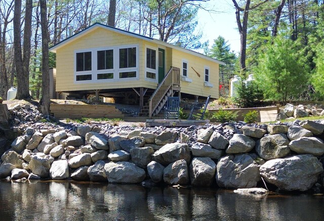 view of front of property with stairs and a water view
