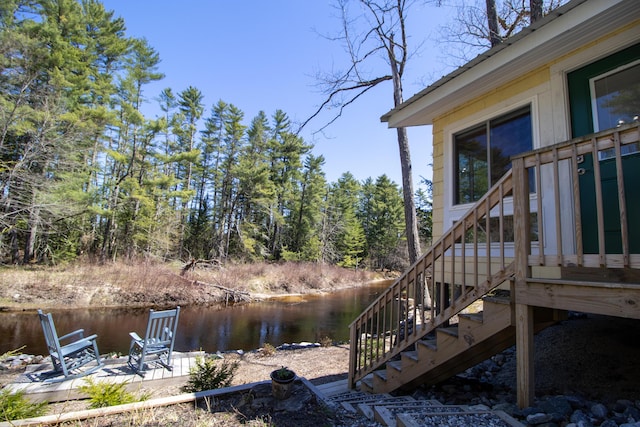view of yard with a water view, stairs, and a patio