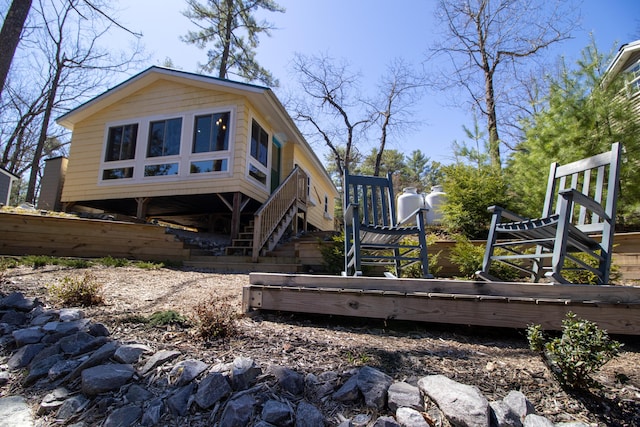 view of side of home featuring stairway and a deck