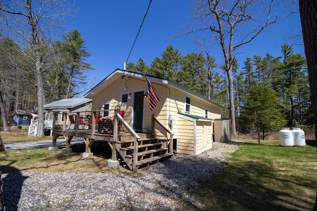 view of front facade featuring a deck and a front yard
