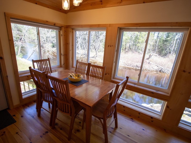 dining area with a water view and light wood-style flooring