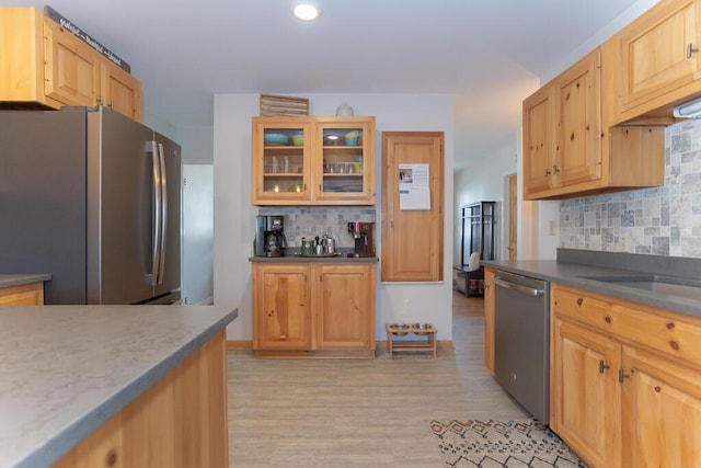 107 Elm St, Farmington, ME 04938 - kitchen featuring recessed lighting, glass insert cabinets, light wood finished floors, decorative backsplash, and stainless steel appliances