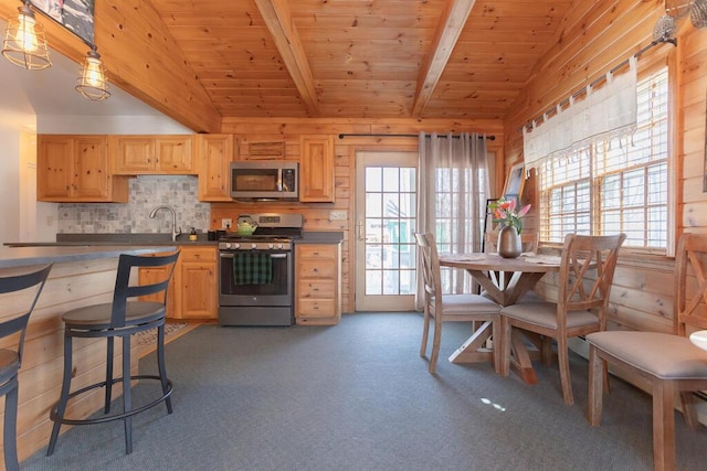 107 Elm St, Farmington, ME 04938 - kitchen with light brown cabinetry, vaulted ceiling with beams, and appliances with stainless steel finishes