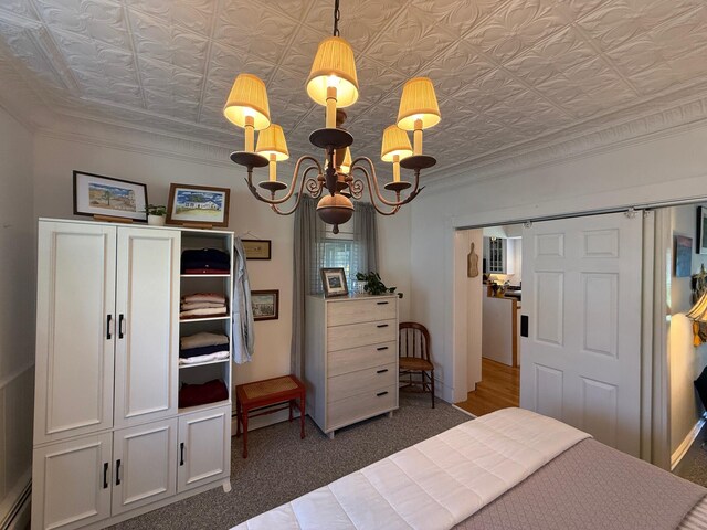 412 N Lubec Rd, Lubec, ME 04652 - carpeted bedroom with an ornate ceiling, a chandelier, baseboard heating, and ornamental molding