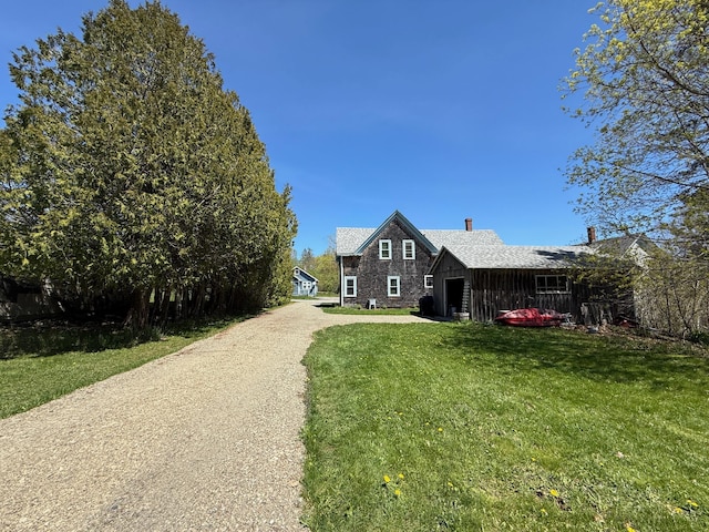 412 N Lubec Rd, Lubec, ME 04652 - view of property exterior featuring driveway, an attached garage, a lawn, and a chimney