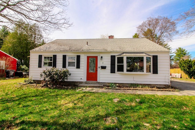ranch-style house with fence, a shingled roof, a front lawn, entry steps, and a chimney