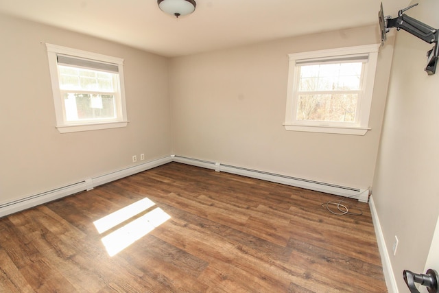 unfurnished room with plenty of natural light, baseboards, and wood finished floors