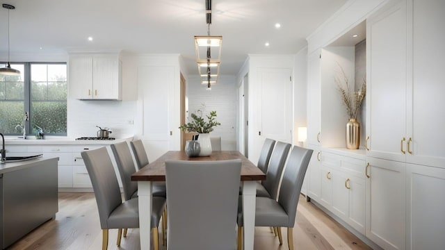 dining room featuring light wood-type flooring, ornamental molding, and recessed lighting