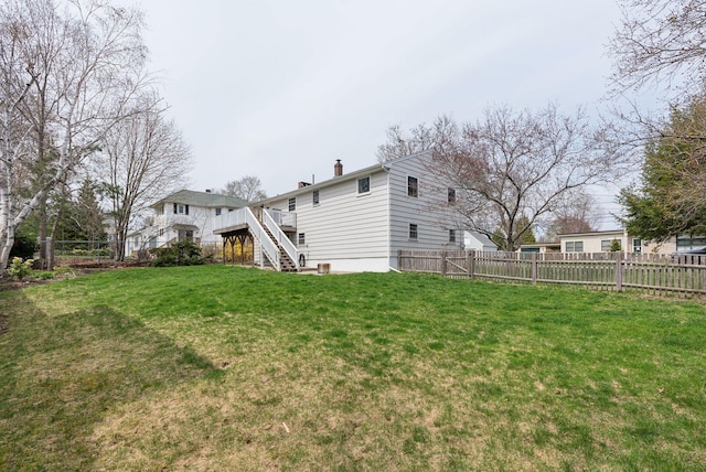 view of yard featuring a deck, stairway, and a fenced backyard