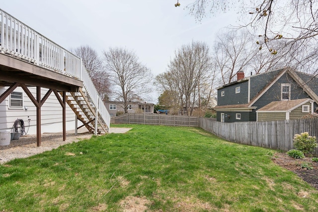 view of yard featuring a deck, stairway, and a fenced backyard