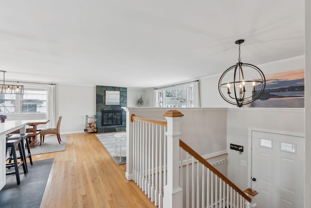 foyer featuring a wealth of natural light, a notable chandelier, a fireplace, and wood finished floors